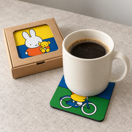 Miffy coaster with rabbit on bicycle design under a mug, in a cardboard box