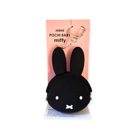 The Miffy Keychain Coin Pouch - Black by Miffy, featuring rabbit ears and made of Japanese silicone, stands out beautifully against a pink backdrop, making it perfect for storing coins.