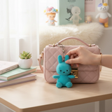 Miffy Corduroy Keychain 10cm - Teal showing a teal corduroy bunny keychain hanging from a pink quilted handbag by Miffy