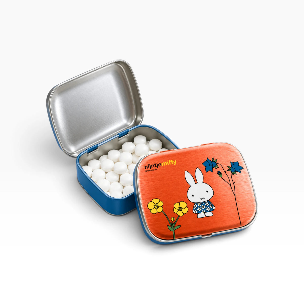 Open blue pill tin with white balls and orange lid featuring Miffy with flowers