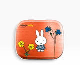 Orange Miffy pill tin with white rabbit and blue flowers illustration