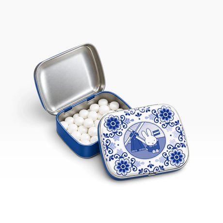 Blue pill tin open with white pills and patterned lid featuring bunny windmill