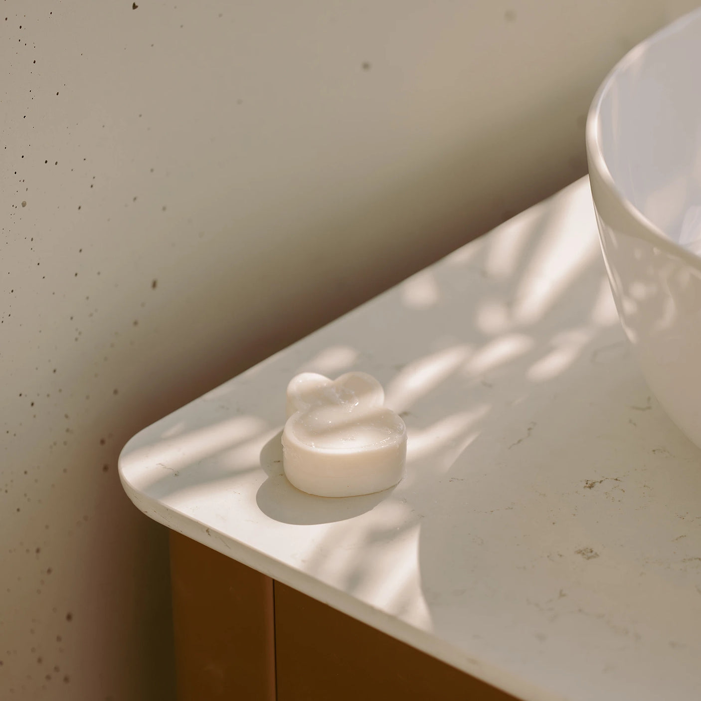 Rabbit-shaped bar soap on a white tray in a bathroom sink