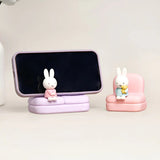 Phone stand sofa set with two rabbit figures on purple and pink seats