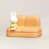 Phone stand sofa with white rabbit figure on orange seat