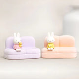 Two phone stand sofas with rabbit figures on lilac and peach seats