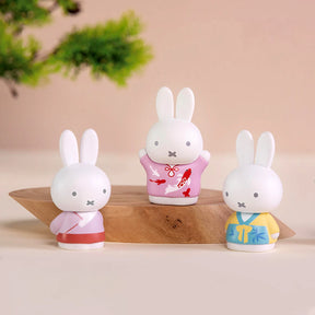 Set of three 6cm Miffy figures in pastel ancient-inspired costumes displayed on wooden stand with soft background
