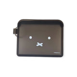 The Miffy Bunny Card Case - Black, by Miffy, is a black rectangular coin purse crafted from durable silicone, featuring a minimalist face design with two white dot eyes and a cross-shaped mouth.