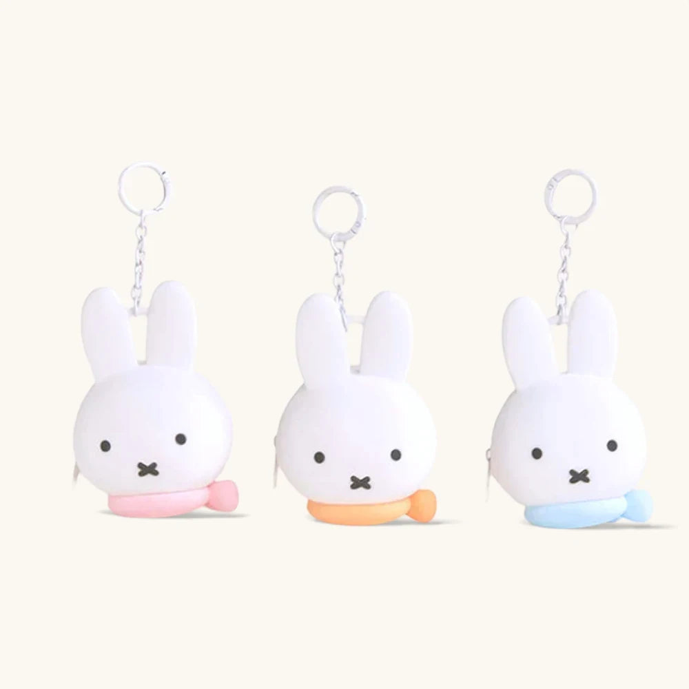 Set of Miffy bunny coin pouch keychains, white plush bunnies with key rings and colorful bases.