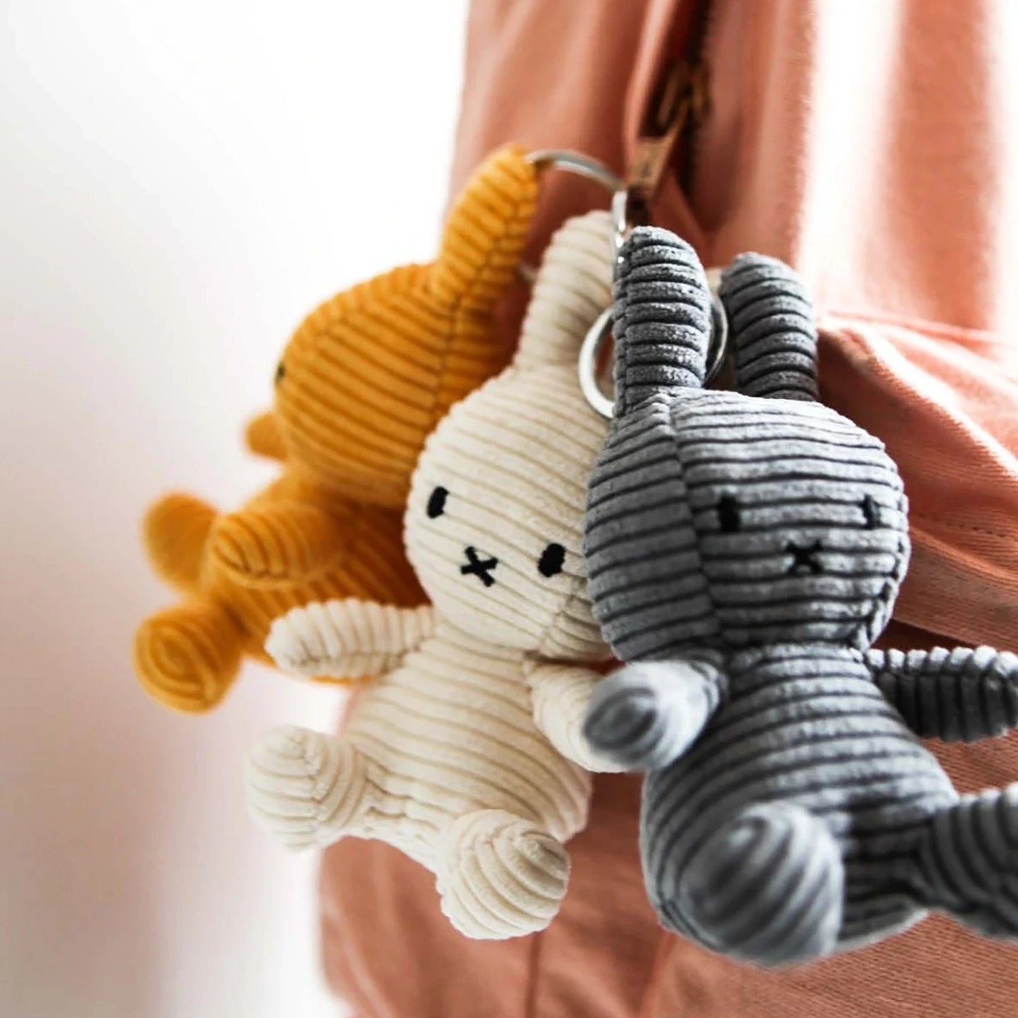 Corduroy bunny keychains in white and gray, each with a metal key ring
