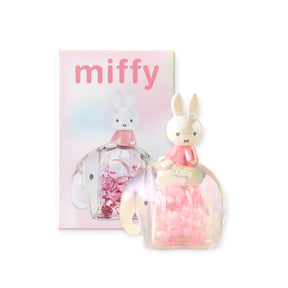 Miffy figure seated atop a translucent pink elephant snowglobe filled with sparkling beads and pastel packaging background