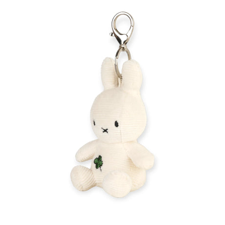 Cream plush bunny keychain facing forward, green four-leaf clover patch