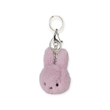 The Miffy Fuzzy Keychain - Lilac features a plush, rabbit-shaped charm in lilac attached to a metal ring and clasp, highlighting sustainable design with eco-friendly materials.