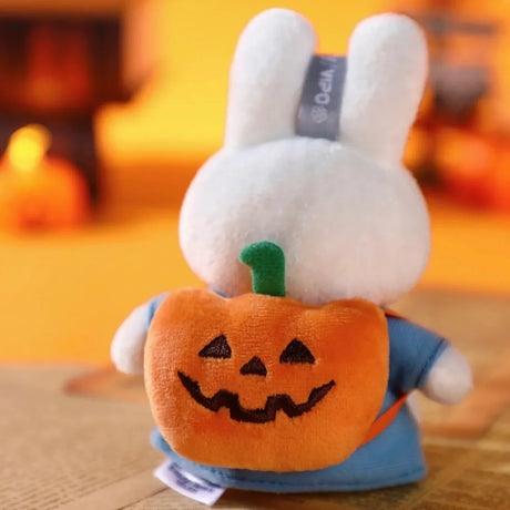 White Miffy plush keychain seen from behind wearing blue outfit and holding jack-o'-lantern pumpkin accessory
