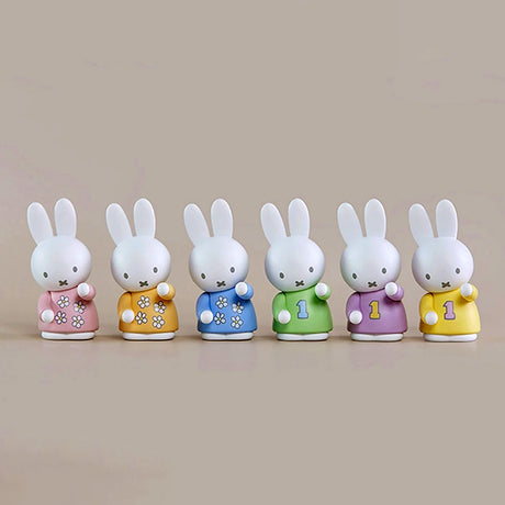 Six Miffy pen tray organisers in pastel and floral outfits with numbers and flowers on beige background