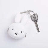 The Miffy Keychain Coin Pouch in white, shaped like a rabbit, doubles as a silicone keychain pouch and is securely attached to a metal key on a chain.