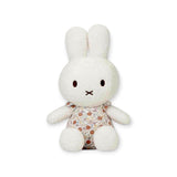 A Miffy Plush White & Vintage Flowers toy, featuring a white rabbit with long ears in a beautiful Vintage Flower Dress, is positioned upright against a plain background.