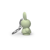 Side view of a small powder-colored rabbit-shaped keychain with a silver chain on a white background, offering a modern twist on the classic Miffy Keychain from the Miffy brand.