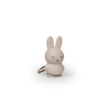 The Miffy Keychain - Powder showcases a small gray rabbit figure with long ears and simple facial features, embracing a minimalist design. Featuring a plain white background, this delightful piece adds a modern flair to your accessories.