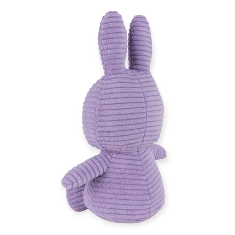 A rear view of the eco-friendly Miffy Bunny Plush Corduroy in lilac, measuring 23cm, with long ears and resembling a bunny, sitting upright.