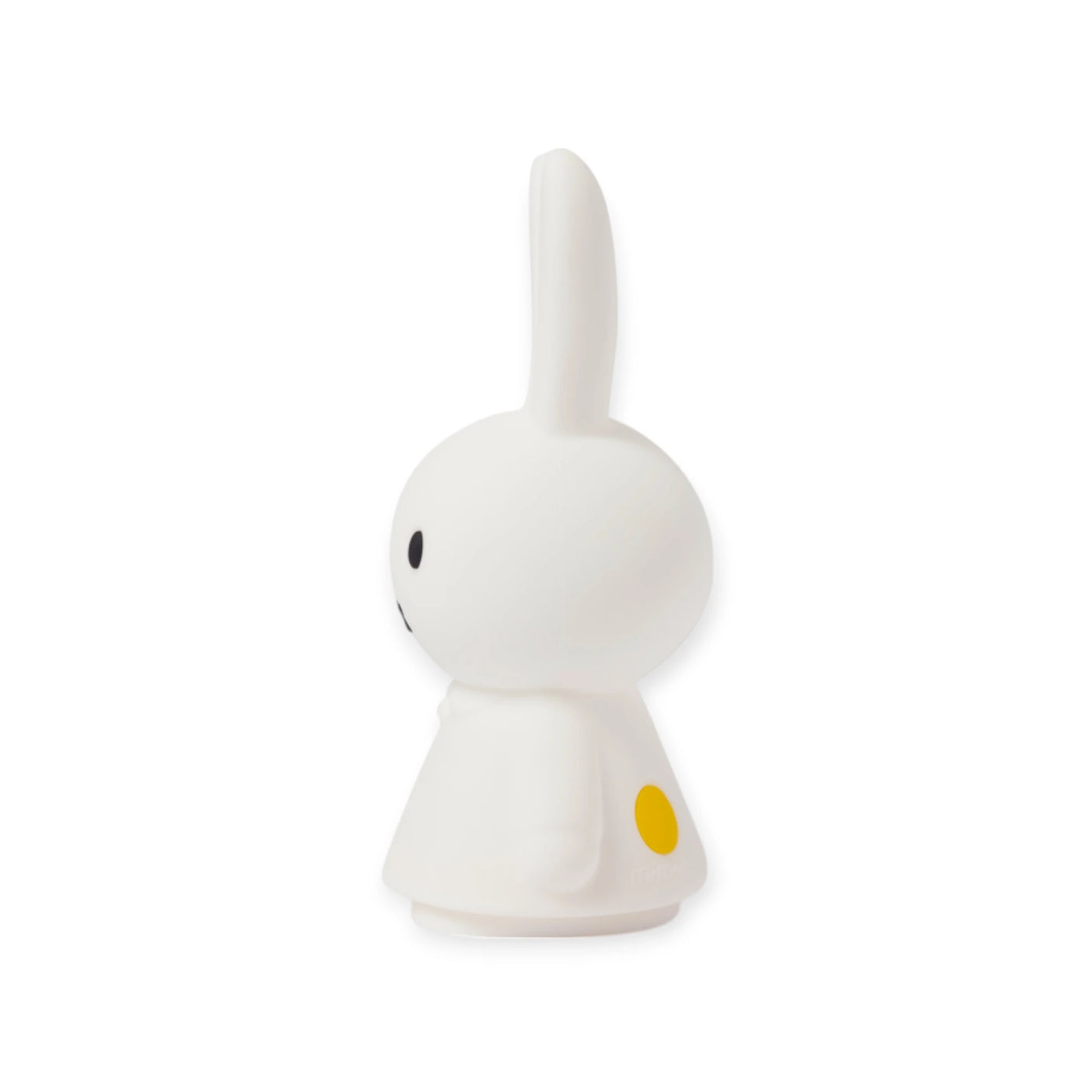 Side view of a small white figurine resembling a minimalistic rabbit with yellow spots, reminiscent of the Miffy Shines - Night Light (22cm) by Miffy. This charming piece captures simplicity and warmth, almost as though it were a rechargeable lamp perfect for cozy corners.