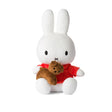 A plush toy featuring Miffy, reminiscent of a white bunny, wears a red shirt and holds a small brown teddy bear.