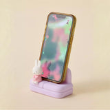 Phone stand sofa with small rabbit figure on light purple base