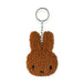 The Miffy Keychain Tiny Teddy Plush - Terry, from the Miffy brand, is an eco-friendly accessory that showcases a brown, textured rabbit face and ears made from terry plush, all secured to a durable metal chain and keyring.