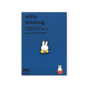 Tiny enamel pin of Miffy with hands under chin on blue backing card with minimal black text and small red Miffy illustration