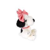 Fuzzy plush dog with pink bow, sitting pose, white-and-black fur