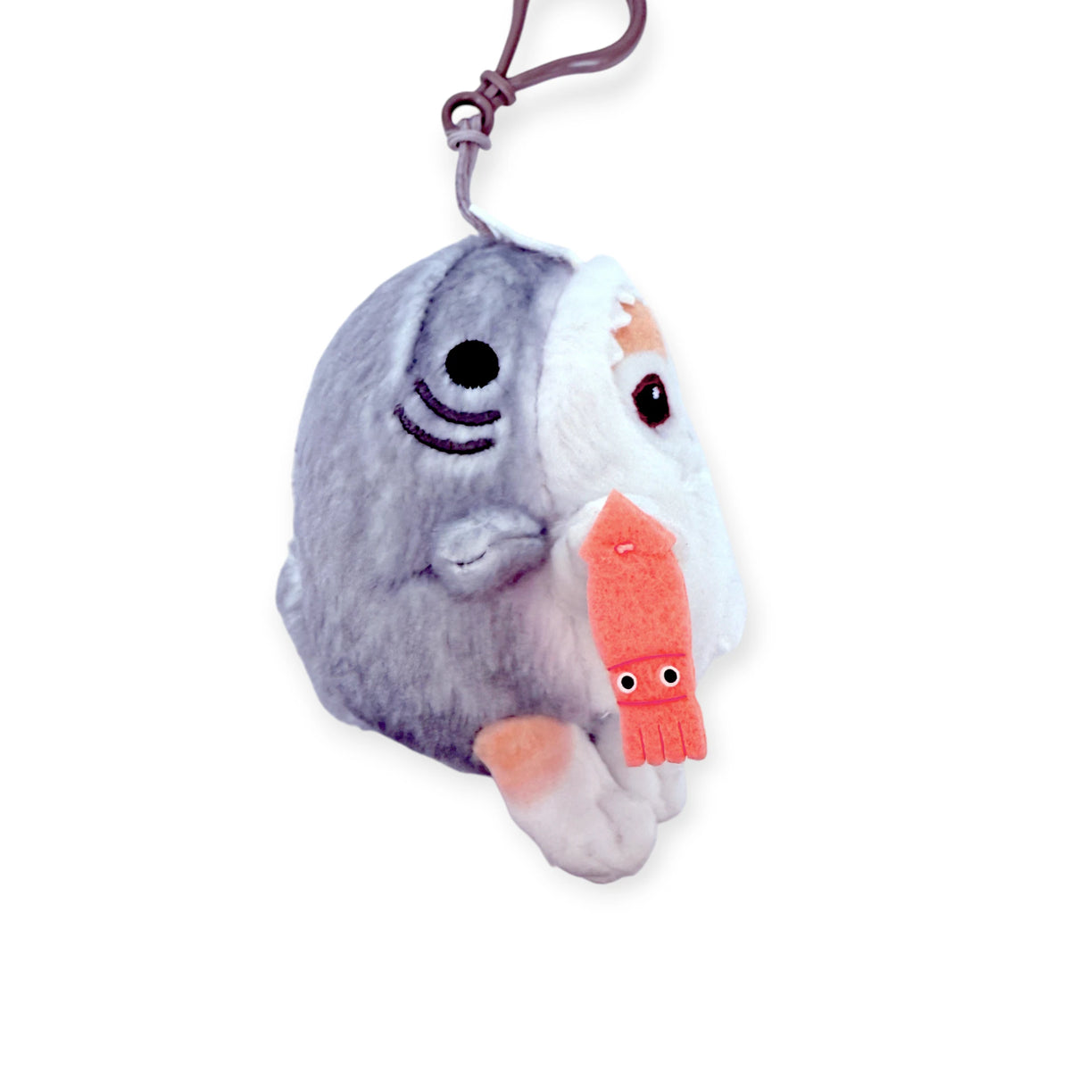 Gray and white plush bag charm with smiling face, orange beak, and purple loop