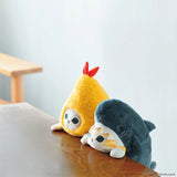 The Mofusand Posture Plush Buddy - Fried Shrimp plush toy, dressed as a shrimp, sits on a wooden surface next to another plush in animal costume by a bench.