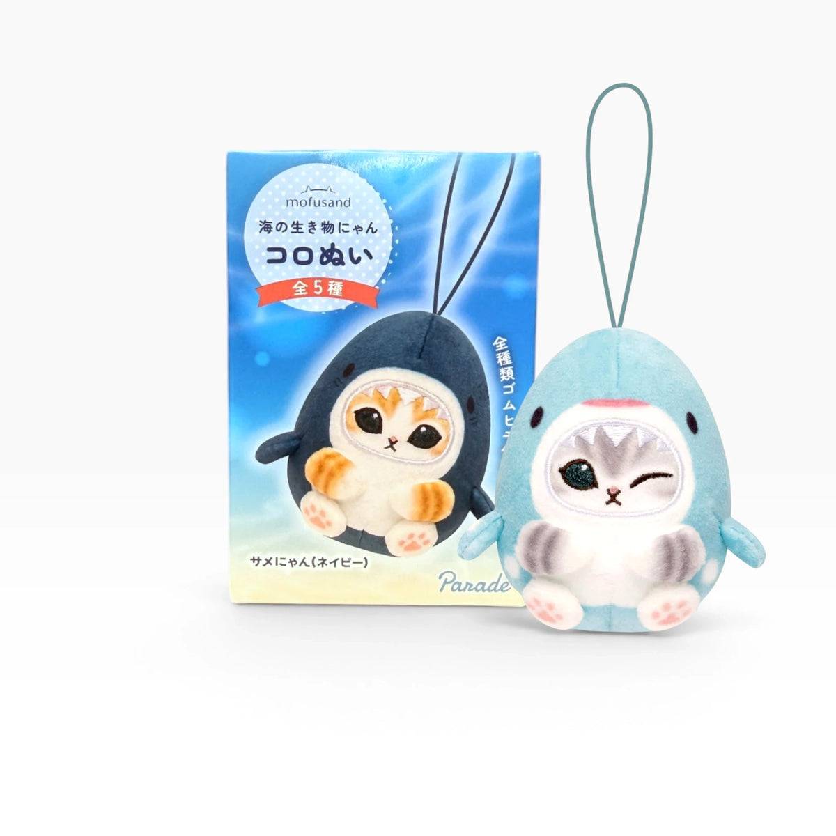 Light blue penguin plush keychain beside a decorative blind box package