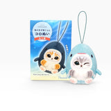 Light blue penguin plush keychain beside a decorative blind box package