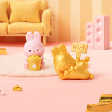 MOMO Bunny 24h Work Life Diary - Blind Box with pastel pink bunny holding popcorn and gold bunny holding a "Rich" sign.