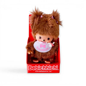 Brown plush doll with soft hat and white bib with pink bow