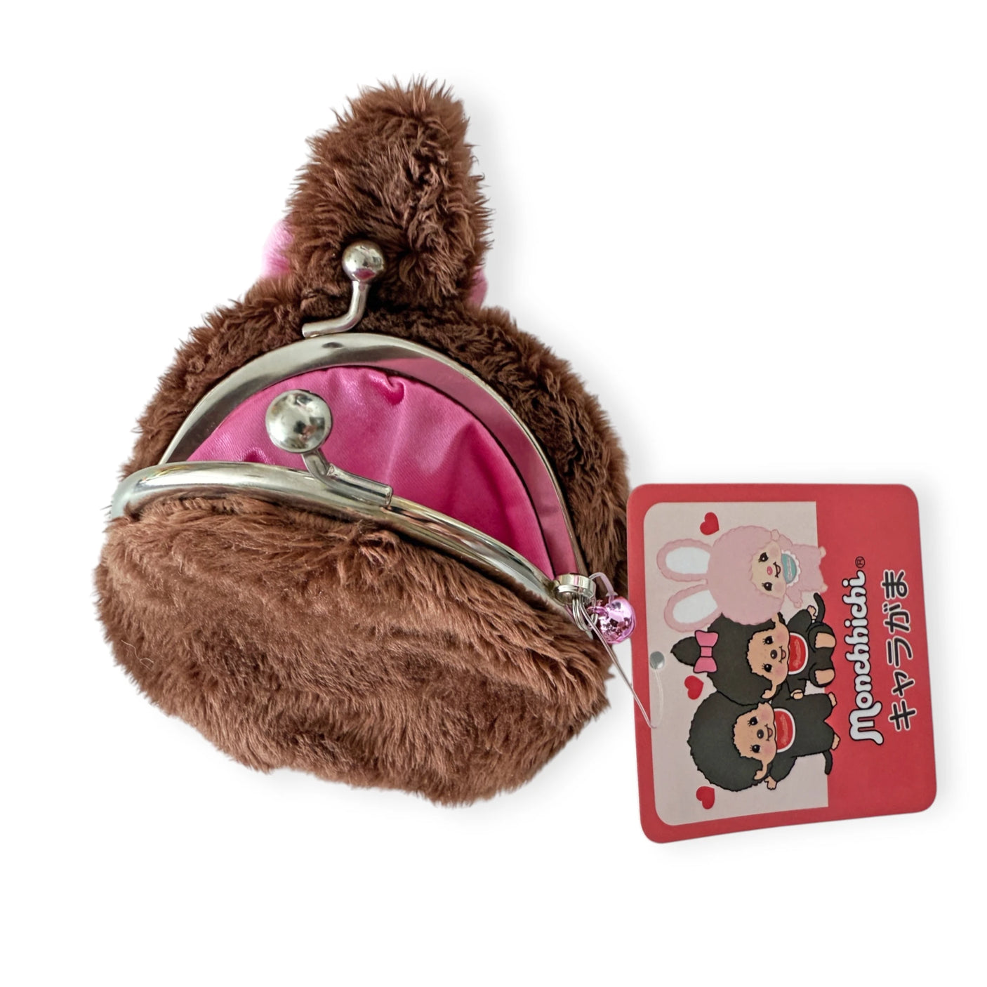 The Monchhichi Coin Pouch - Girl by Monchhichi has a metal clasp and pink fabric lining. Made of soft plush material, it features an attached tag with adorable cartoon characters and Japanese text for a charming touch.