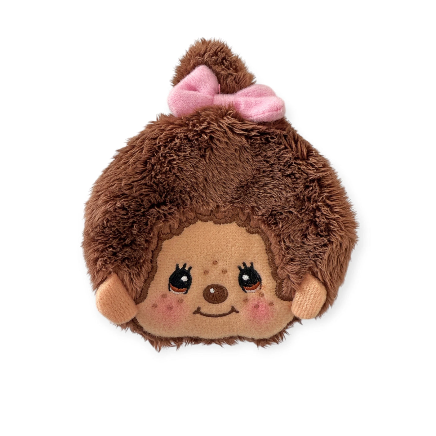 The Monchhichi Coin Pouch - Girl by Monchhichi is a circular plush accessory featuring a smiling face, brown fur, rosy cheeks, and a pink bow on top. Made from soft plush material, it's both cozy and adorable.