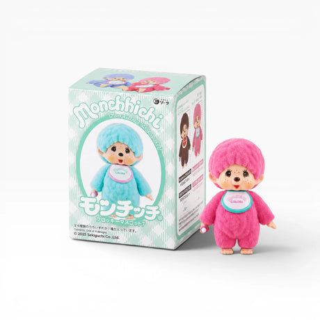 Monchhichi flocked figure in pink with hood, standing beside blind box