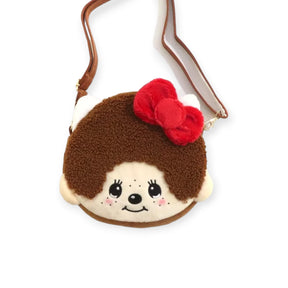 The Monchhichi x Hello Kitty Shoulder Bag by Monchhichi is a Japan exclusive, shaped like a brown animal face with a red bow, white ears, and features a brown adjustable strap.