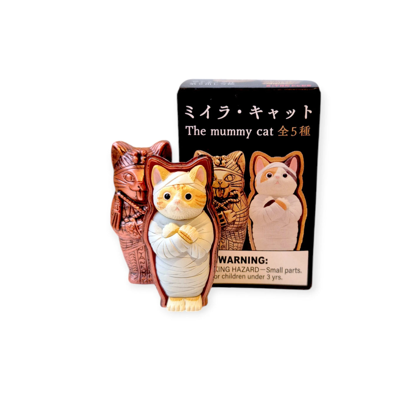 Toy figures designed like mummified cats are packaged in the Mummy Cat Blind Box from Kitan Club, featuring a sarcophagus design and a warning about small parts.