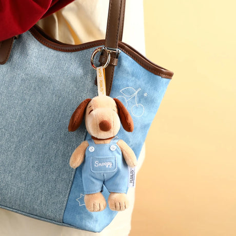 Denim tote bag with Snoopy plush keychain charm on gold keyring and brown strap