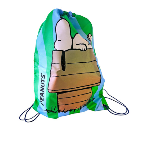 Green and blue Peanuts drawstring bag featuring Snoopy lying on doghouse with black cords and PEANUTS text on side