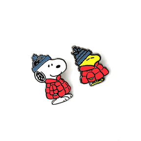 Snoopy and Woodstock enamel pins wearing red puffers and blue hats on white background, peanuts_snoopy-woodstock-pins.webp