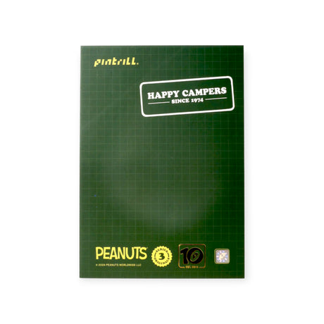 Green card backing with white text Happy Campers Since 1974 and Peanuts branding on bottom edge