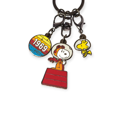 The Snoopy & Woodstock in Space Keychain by Snoopy features three charms: a round "1969" charm, NASA Snoopy in an astronaut s