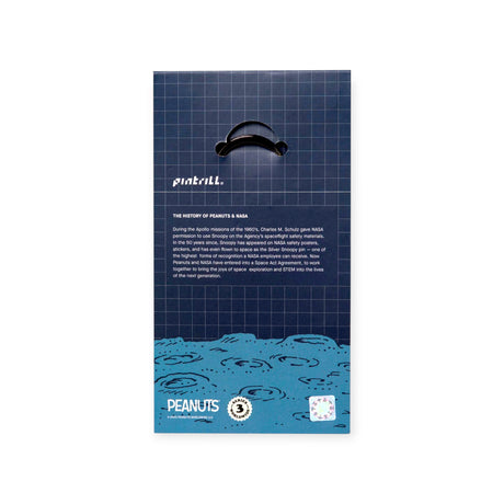 The back of the Snoopy & Woodstock in Space Keychain package features a brief history about Peanuts and NASA Snoopy, with blue wave graphics, a dark grid background, and the Snoopy brand logo, highlighting unique Peanuts merchandise.