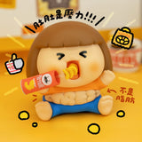 Vinyl collectible character figure lying down in orange shirt and blue pants, holding drink bottle