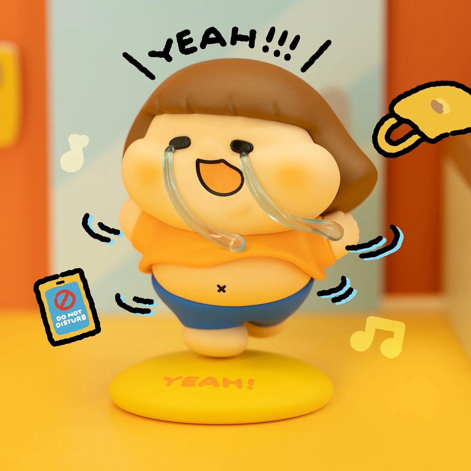 Vinyl collectible character figure in tan cap and blue overalls, holding clear headset