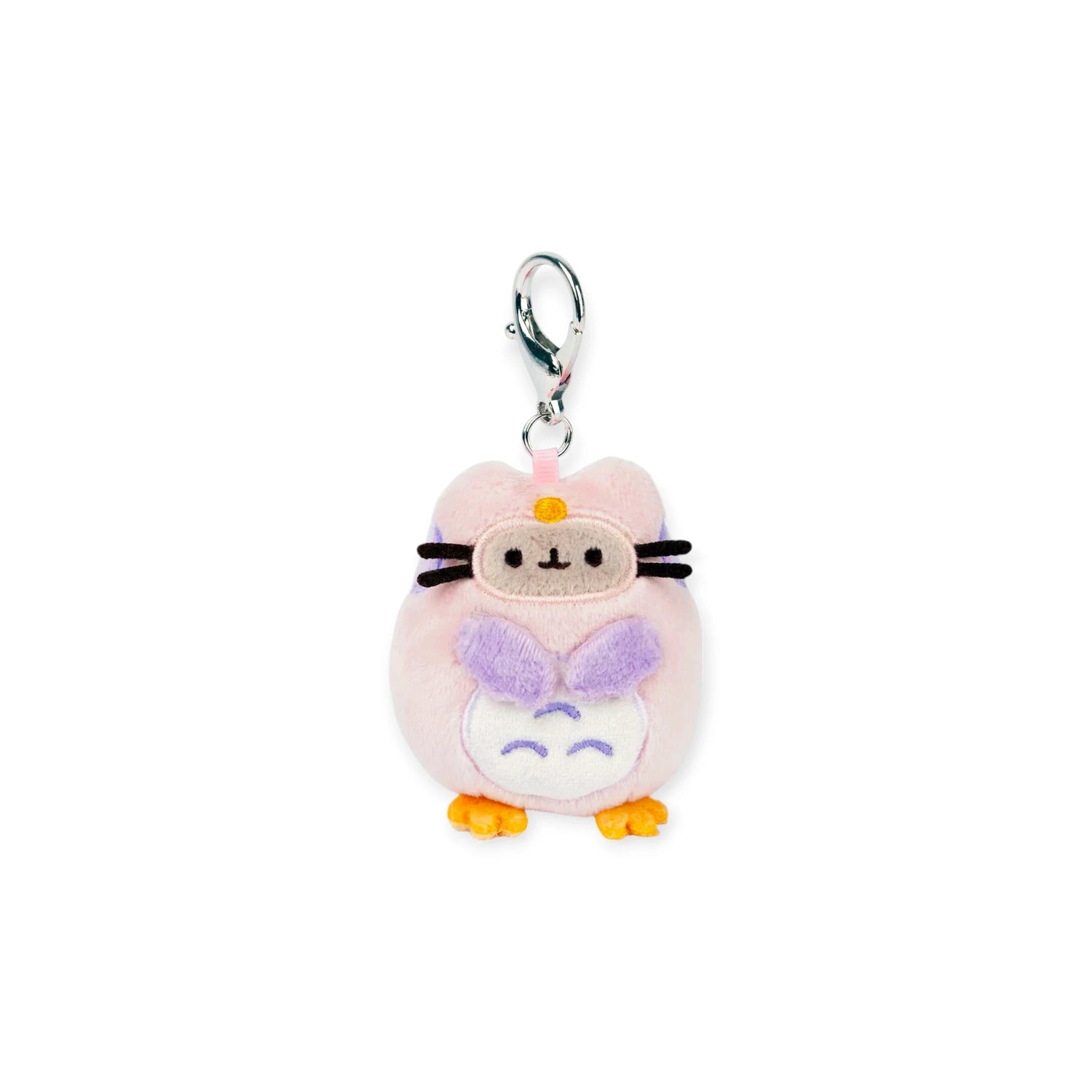The Pusheen Blind Box - Enchanted Forest by Pusheen features a round, pale pink cat plush keychain with black whiskers, an orange nose, and a purple bow—ideal for fans and Blind Box collectors.
